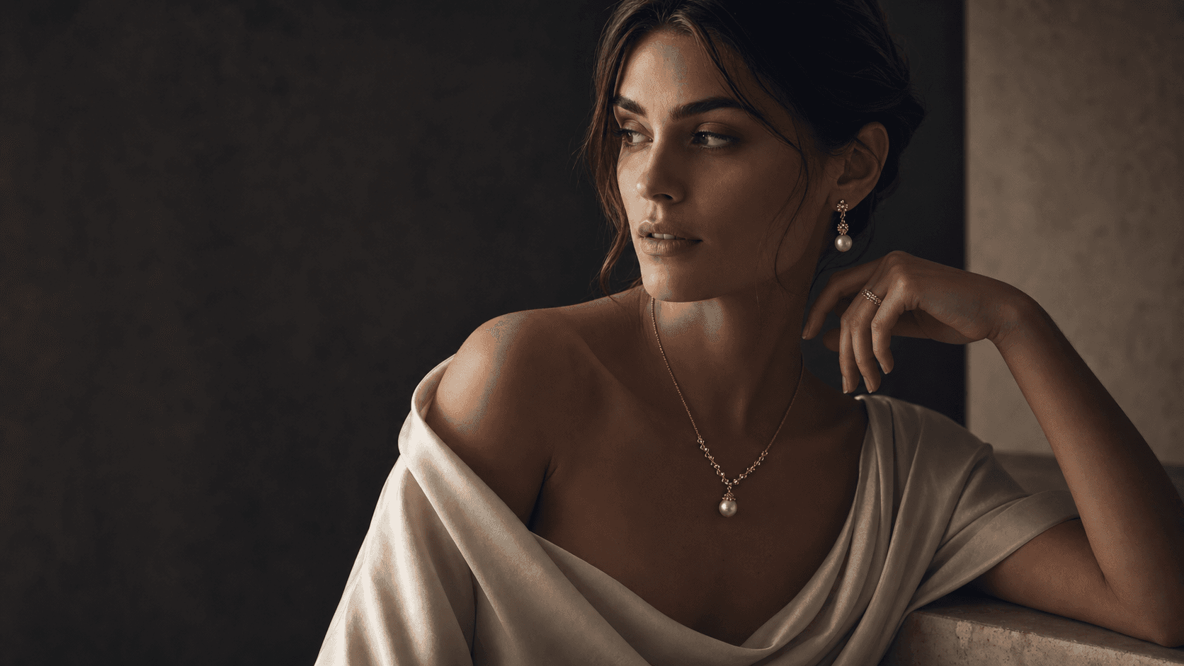 Cinematic editorial portrait with handcrafted cultural jewelry on charcoal silk and warm stone.